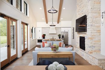 A modern living room with a stone fireplace and a large couch.